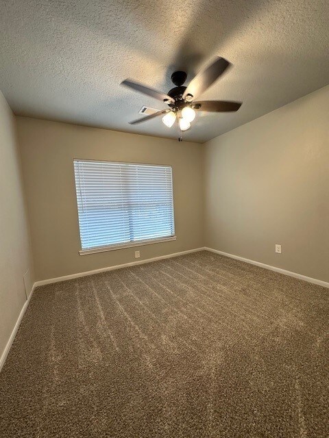 2102 Autumn Cove Dr, League City, TX 77573 - empty room with a ceiling fan, a textured ceiling, and carpet