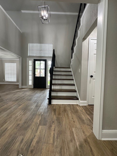 2102 Autumn Cove Dr, League City, TX 77573 - foyer entrance with stairway, a high ceiling, wood finished floors, a chandelier, and a textured wall