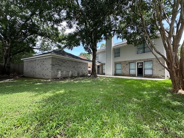 2102 Autumn Cove Dr, League City, TX 77573 - rear view of house featuring a yard, brick siding, and a chimney