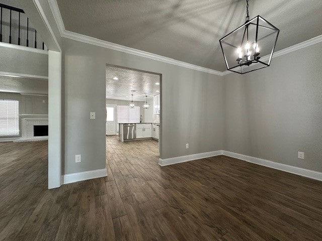 2102 Autumn Cove Dr, League City, TX 77573 - unfurnished dining area with a chandelier, dark wood-style flooring, ornamental molding, a brick fireplace, and a textured ceiling