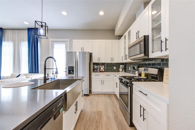 320 Parker Willow Ln, Houston, TX 77076 - kitchen featuring appliances with stainless steel finishes, glass insert cabinets, white cabinetry, decorative backsplash, and recessed lighting