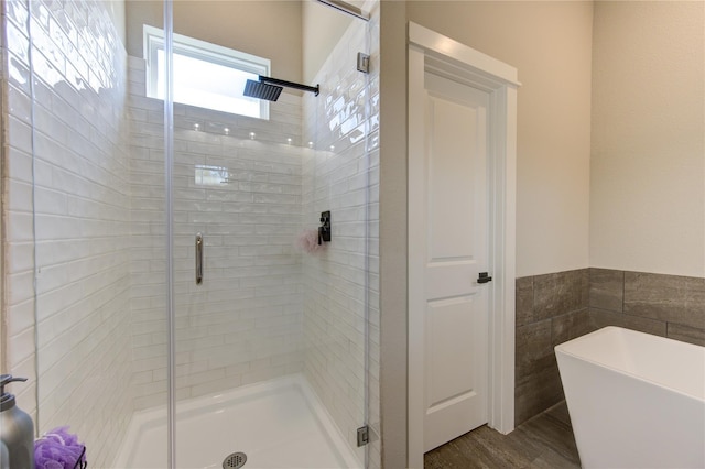 320 Parker Willow Ln, Houston, TX 77076 - bathroom featuring a stall shower, a freestanding tub, wood finished floors, and tile walls