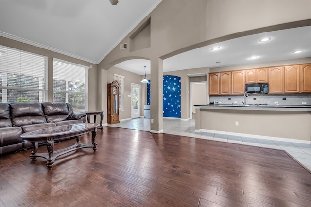 5531 Cherish Trl, Katy, TX 77494 - living room featuring arched walkways, light wood-style floors, ornamental molding, recessed lighting, and high vaulted ceiling