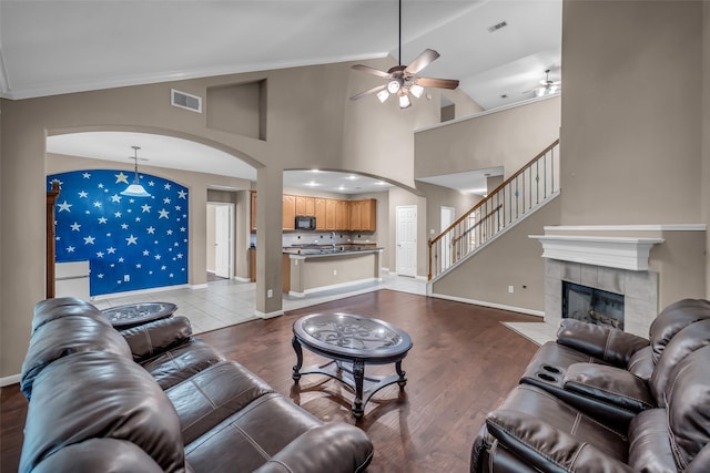 5531 Cherish Trl, Katy, TX 77494 - living room featuring ceiling fan, arched walkways, vaulted ceiling, wood finished floors, and a fireplace