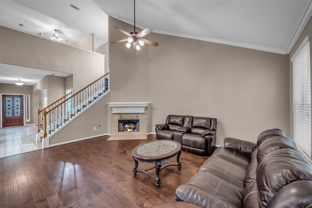 5531 Cherish Trl, Katy, TX 77494 - living area featuring ceiling fan, stairs, arched walkways, wood finished floors, and a tiled fireplace