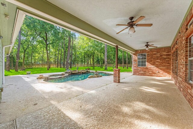 27210 Hitching Post Ct, Magnolia, TX 77355 - fenced backyard featuring a ceiling fan, a patio area, a pool with connected hot tub, and view of scattered trees