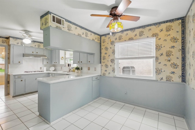 7826 Braesview Ln, Houston, TX 77071 - kitchen with a ceiling fan, a peninsula, under cabinet range hood, gas stovetop, and wallpapered walls