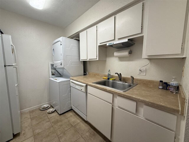 5711 Sugar Hill Dr Unit 46, Houston, TX 77057 - kitchen with white appliances, stacked washer / drying machine, white cabinets, a textured wall, and light tile patterned floors