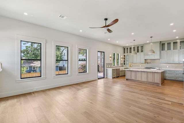 1023 Grovewood Ln, Houston, TX 77008 - kitchen with light countertops, ceiling fan, a center island, appliances with stainless steel finishes, and light wood-style flooring