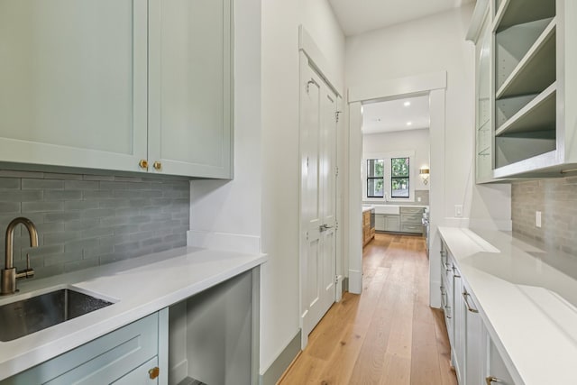 1023 Grovewood Ln, Houston, TX 77008 - kitchen with decorative backsplash, light wood-style floors, light countertops, recessed lighting, and glass insert cabinets