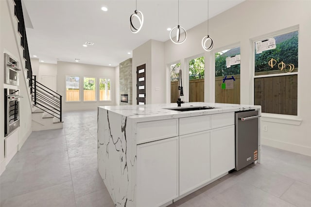 5117 Schuler St Unit B, Houston, TX 77007 - kitchen with a center island, recessed lighting, light stone countertops, white cabinets, and decorative light fixtures