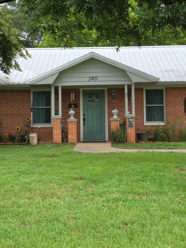 2401 Country Meadows Ln, Brenham, TX 77833 - single story home featuring a front lawn, a metal roof, and brick siding