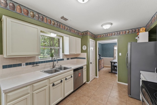 17010 Cypress Knee Dr, Cypress, TX 77429 - kitchen with stainless steel dishwasher, range with electric cooktop, light tile patterned flooring, light countertops, and a textured ceiling