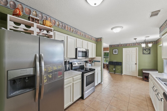17010 Cypress Knee Dr, Cypress, TX 77429 - kitchen featuring stainless steel appliances, light countertops, white cabinets, light tile patterned flooring, and decorative backsplash