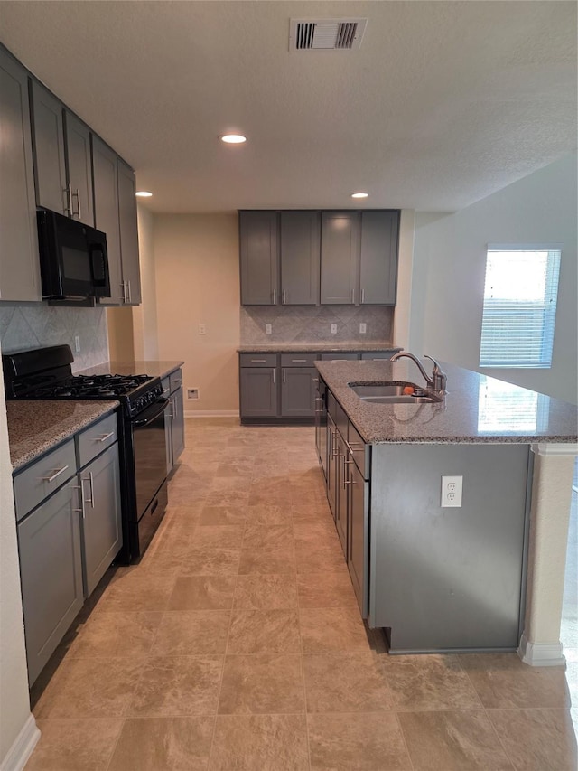 15319 Roaming River Trl, Houston, TX 77044 - kitchen featuring black appliances, stone counters, tasteful backsplash, a kitchen island with sink, and recessed lighting