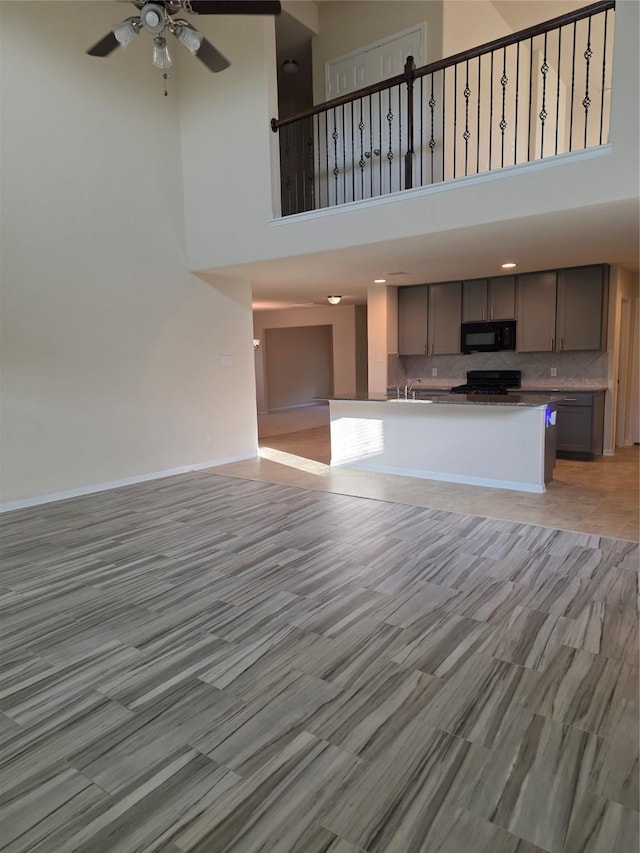 15319 Roaming River Trl, Houston, TX 77044 - unfurnished living room with a towering ceiling and a ceiling fan