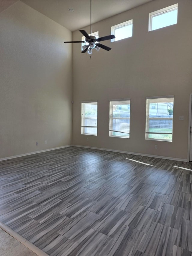 15319 Roaming River Trl, Houston, TX 77044 - spare room featuring a towering ceiling, a ceiling fan, healthy amount of natural light, and wood finished floors