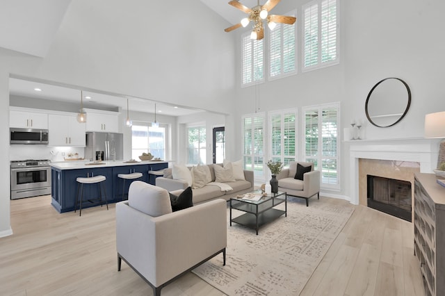 1622 Maryvale Dr, Katy, TX 77494 - living area with a ceiling fan, light wood-style flooring, high vaulted ceiling, a premium fireplace, and recessed lighting