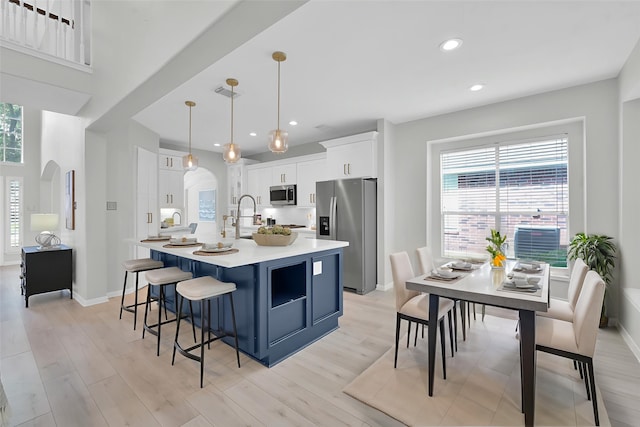 1622 Maryvale Dr, Katy, TX 77494 - kitchen featuring appliances with stainless steel finishes, light countertops, a spacious island, white cabinetry, and healthy amount of natural light