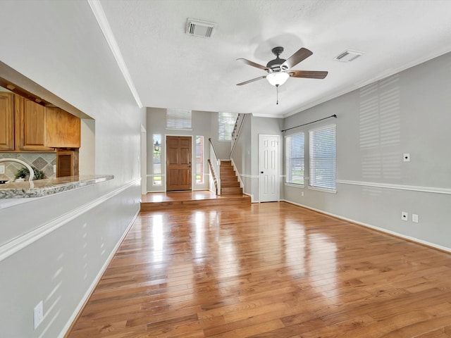 1227 Redwood Bough Ln, Houston, TX 77062 - unfurnished living room with ornamental molding, light wood-style flooring, stairway, ceiling fan, and a textured ceiling
