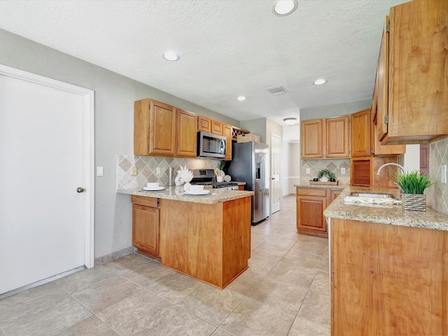 1227 Redwood Bough Ln, Houston, TX 77062 - kitchen with appliances with stainless steel finishes, a peninsula, decorative backsplash, light stone counters, and recessed lighting
