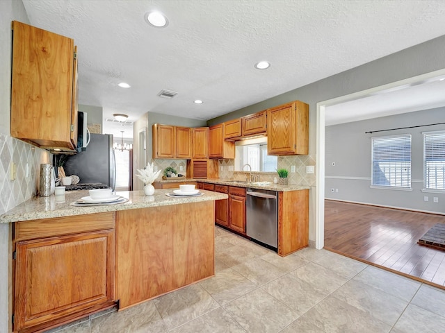 1227 Redwood Bough Ln, Houston, TX 77062 - kitchen with stainless steel appliances, a peninsula, backsplash, light tile patterned flooring, and a textured ceiling