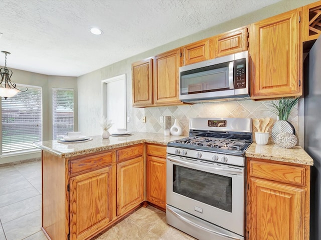 1227 Redwood Bough Ln, Houston, TX 77062 - kitchen featuring appliances with stainless steel finishes, a peninsula, light stone counters, decorative backsplash, and a textured ceiling