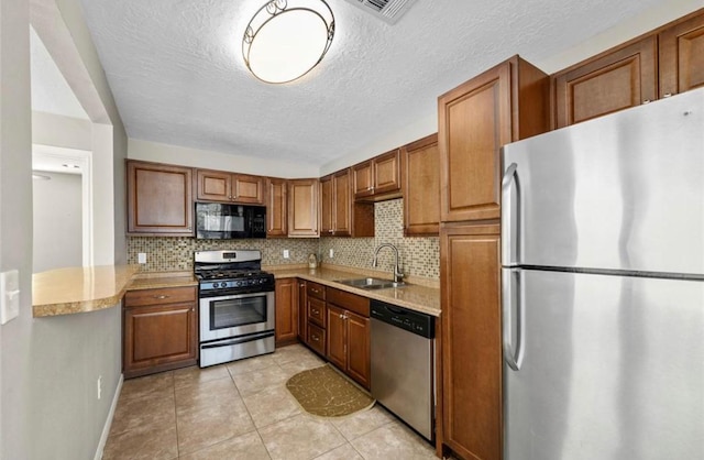 1115 Alber St, Houston, TX 77009 - kitchen with stainless steel appliances, light countertops, tasteful backsplash, and a textured ceiling