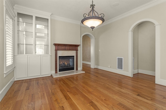6616 Queensclub Dr, Houston, TX 77069 - unfurnished living room featuring arched walkways, crown molding, wood finished floors, and a fireplace