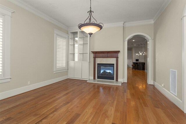 6616 Queensclub Dr, Houston, TX 77069 - unfurnished living room with wood finished floors, ornamental molding, a high end fireplace, and arched walkways