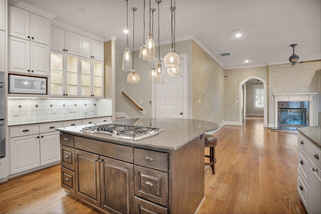 6616 Queensclub Dr, Houston, TX 77069 - kitchen featuring stainless steel appliances, ornamental molding, arched walkways, white cabinetry, and decorative backsplash