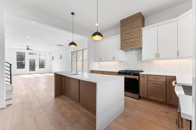 5505 Kansas St, Houston, TX 77007 - kitchen featuring stainless steel gas stove, range hood, light wood-type flooring, backsplash, and recessed lighting