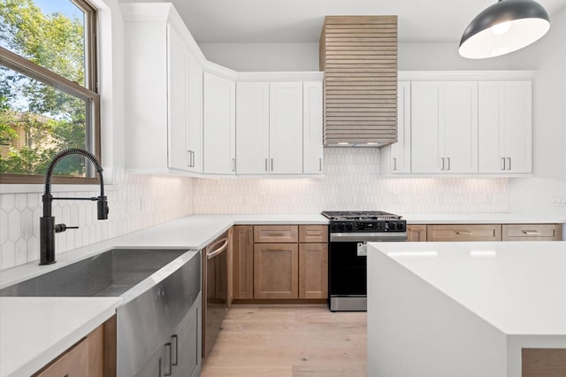 5505 Kansas St, Houston, TX 77007 - kitchen with appliances with stainless steel finishes, extractor fan, light wood-style floors, backsplash, and light countertops
