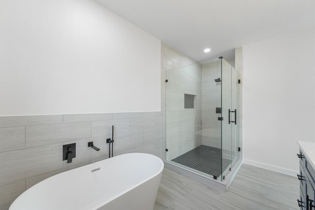 256 Davis Bend Rd, Alvin, TX 77511 - bathroom featuring a freestanding bath, a shower stall, vanity, recessed lighting, and tile walls