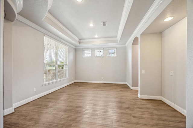 4906 Lodge Lake Dr, Fulshear, TX 77441 - empty room with a raised ceiling, crown molding, light wood-style flooring, recessed lighting, and arched walkways