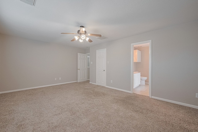 9714 Angleside Ln, Sugar Land, TX 77498 - unfurnished bedroom featuring light colored carpet, connected bathroom, and a ceiling fan