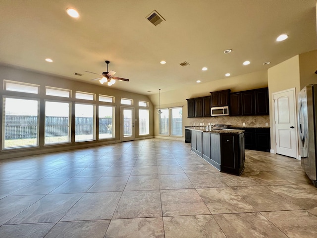 22223 Slate Oaks Ln, Richmond, TX 77469 - kitchen featuring appliances with stainless steel finishes, open floor plan, ceiling fan, recessed lighting, and decorative backsplash