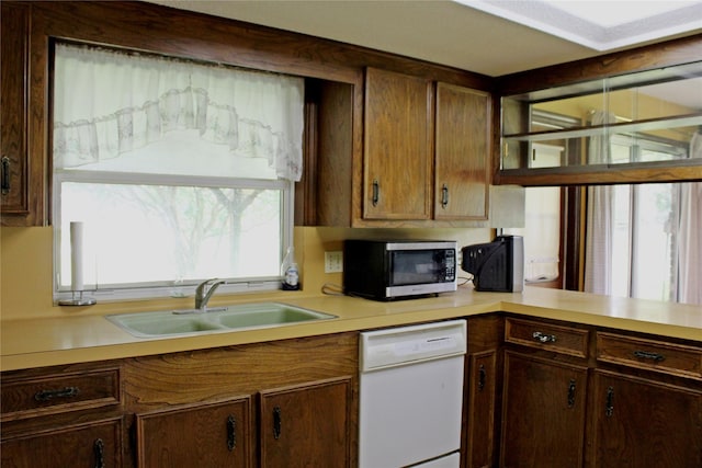 216 N St, Columbus, TX 78934 - kitchen with dishwasher, stainless steel microwave, light countertops, and dark brown cabinetry