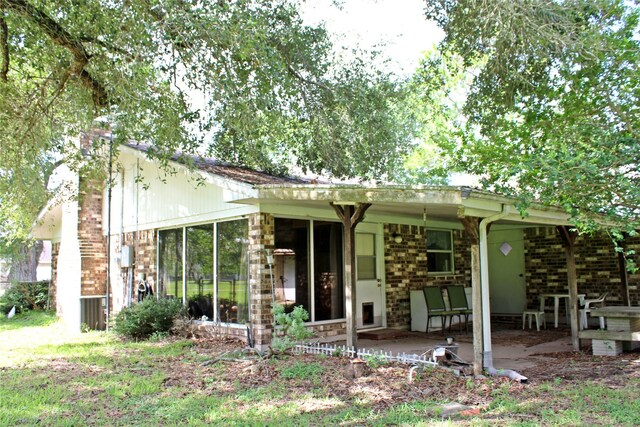 216 N St, Columbus, TX 78934 - view of front of property with brick siding, a sunroom, and a patio