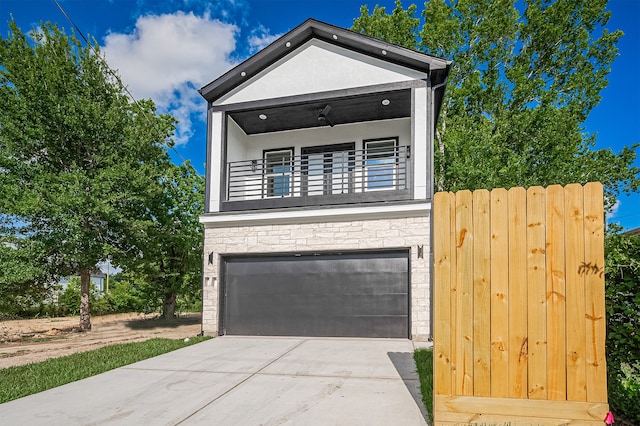 6747 Liverpool St, Houston, TX 77021 - view of front of property with stone siding, a garage, driveway, and a balcony