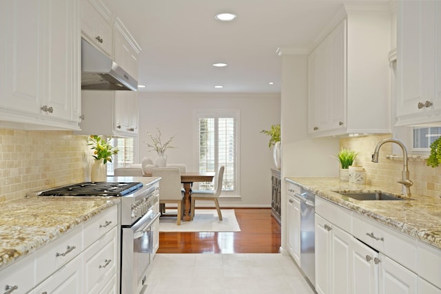 2200 Potomac Dr, Houston, TX 77057 - kitchen featuring appliances with stainless steel finishes, under cabinet range hood, white cabinets, light stone counters, and recessed lighting