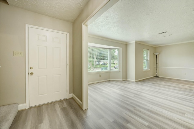 11823 Blair Meadow Dr, Meadows Place, TX 77477 - foyer with a textured ceiling, light wood-type flooring, and ornamental molding