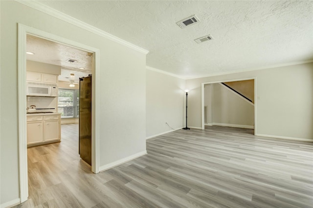 11823 Blair Meadow Dr, Meadows Place, TX 77477 - spare room with light wood finished floors, a textured ceiling, and ornamental molding