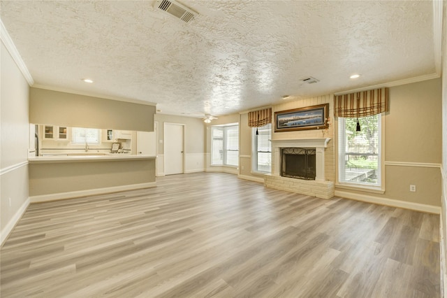 11823 Blair Meadow Dr, Meadows Place, TX 77477 - unfurnished living room featuring a textured ceiling, a fireplace, wood finished floors, ornamental molding, and recessed lighting
