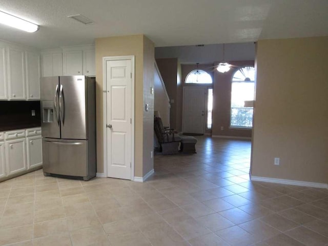 70 Lakeside, Trinity, TX 75862 - kitchen featuring stainless steel fridge, light tile patterned flooring, white cabinetry, ceiling fan, and dark countertops