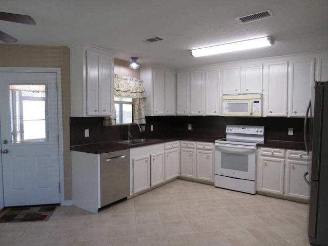 70 Lakeside, Trinity, TX 75862 - kitchen with stainless steel appliances, dark countertops, white cabinetry, a ceiling fan, and light tile patterned flooring
