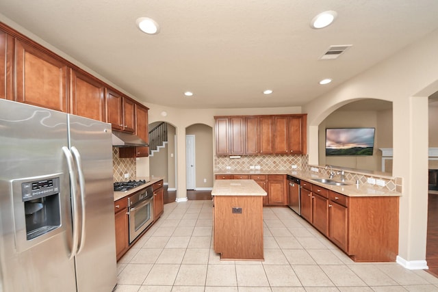 30041 Willow Walk Ln, Brookshire, TX 77423 - kitchen with stainless steel appliances, a center island, under cabinet range hood, backsplash, and light countertops
