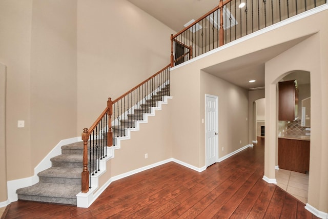 30041 Willow Walk Ln, Brookshire, TX 77423 - staircase featuring arched walkways, hardwood / wood-style flooring, a towering ceiling, and recessed lighting