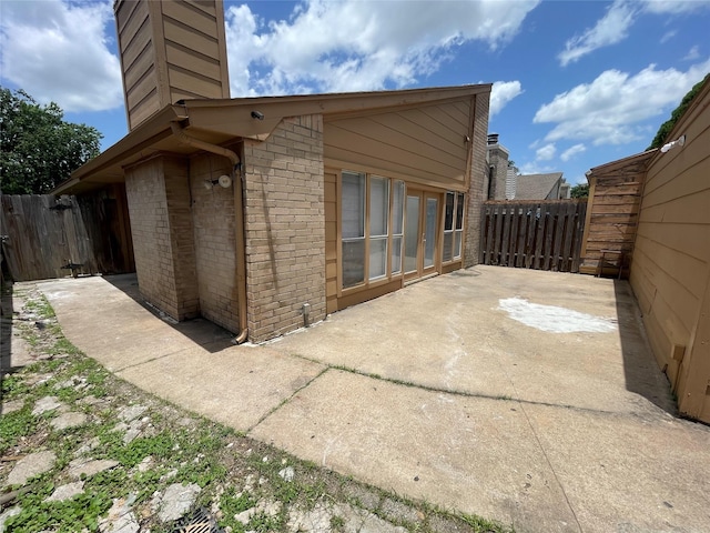 4202 Boone Rd, Houston, TX 77072 - view of side of property featuring brick siding, a patio area, a chimney, and french doors