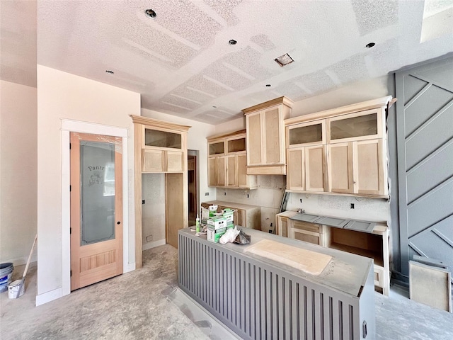 1162 Rd 6604, Dayton, TX 77535 - kitchen with light brown cabinets, a textured ceiling, a kitchen island, and concrete flooring